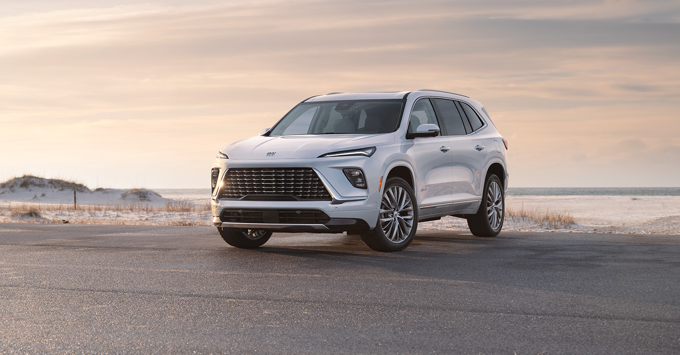 2025 Buick Enclave white midsize SUV parked near a coastal roadway